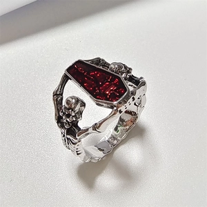 Close-up of gothic silver ring featuring a red coffin stone and skeleton accents