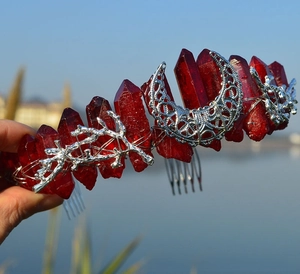 Macro shot of red crystal crown with silver moon and twig details on a handmade headband