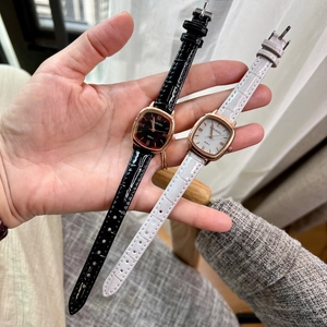 Close-up of square dial women's watches in black and white leather straps with Roman numerals