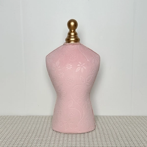 Detail of pink bust jewelry display stand with embossed floral fabric and gold top finial