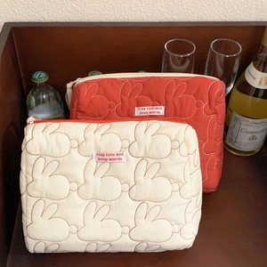 Macro detail of quilted rabbit pattern and woven label on a cotton makeup bag