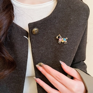 Close-up of a colorful enamel horse brooch with crystals pinned on a dark coat lapel