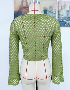 Detail of green crochet knit sweater featuring breathable hollow-out mesh and flare sleeves