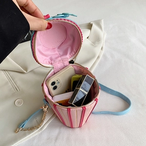 Pink cupcake-shaped crossbody bag with phone and lipstick storage on white blazer