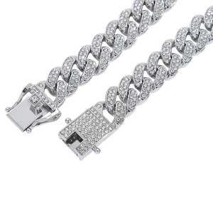 Close-up of a silver iced-out Cuban chain with detailed diamond setting and box clasp