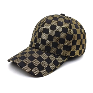 Macro detail of the black and gold checkered texture on a stylish baseball cap