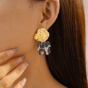 Detailed close-up of a vintage resin leopard print earring with a gold irregular texture
