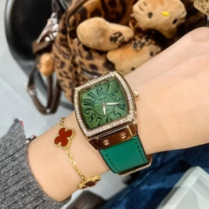 Close-up of a green dial square quartz watch with diamond bezel and leather strap