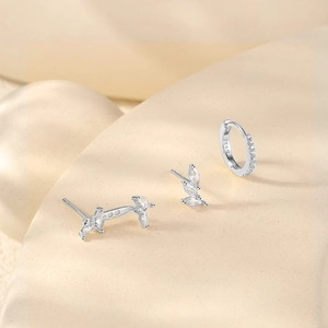Close-up of S925 sterling silver leaf studs and zircon hoop earring set on a beige base