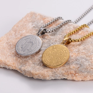 Saint Benedict Medal necklaces in gold and silver finish on a natural stone base