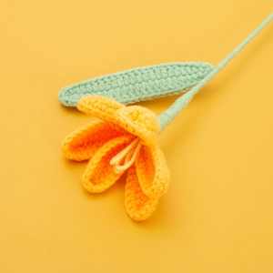 Detailed knit texture of handmade yellow tulip crochet flower with light green stem