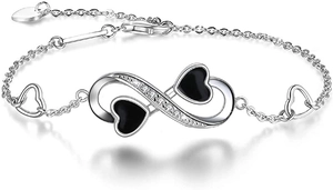 Close-up of infinity and black enamel heart charm bracelet with sparkling crystals