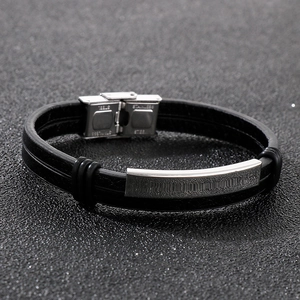Close-up of black braided leather bracelet with polished stainless steel clasp and plate