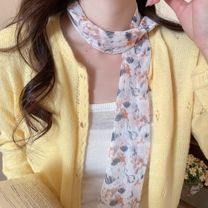 Close-up of pastoral floral mesh scarf necklace paired with soft yellow cardigan