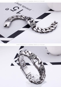 Close-up of silver Cuban chain bracelet with tribal engravings and secure box clasp