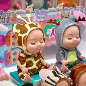 Close-up of 5-inch sleeping baby dolls dressed in giraffe and reindeer plush outfits