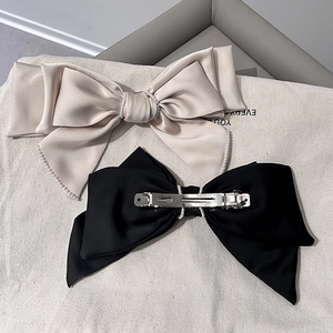 Elegant satin bow hair clips with pearl trim in champagne and black colors