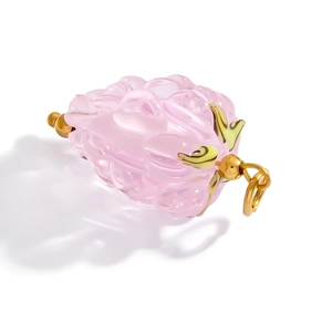 Detailed macro view of pink glass fruit pendant with 18k gold-plated stainless steel leaf