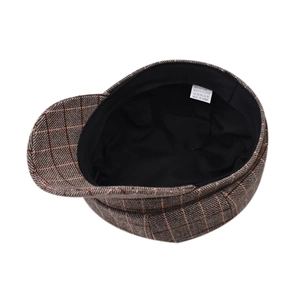 Detail view of plaid newsboy cap interior showing the fabric lining and material composition label