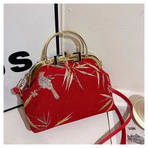 Detail of red Hanfu handbag with golden bird and bamboo embroidery and metal ring handle