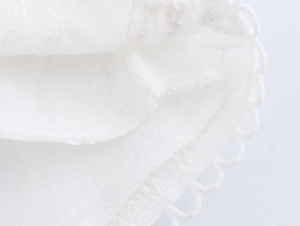 Close-up of intricate lace trim and breathable cotton fabric texture on white shorts