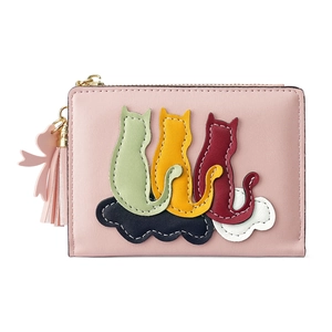 Close-up of pink cat embroidery on faux leather wallet with tassel and bow charm