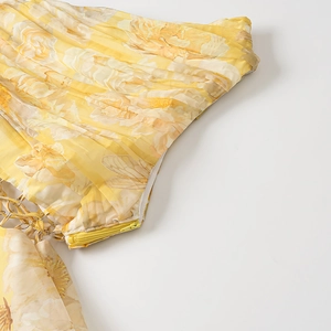 Detail of yellow floral dress showing invisible zipper and metal buckle attachment