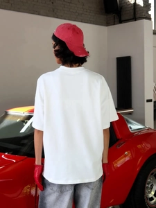 Λεπτομερής προβολή λευκού βαμβακερού t-shirt oversize με στάμπα γραμμάτων street