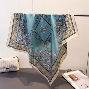 Light blue floral silk scarf with grey ink-wash patterns draped on a metal rack