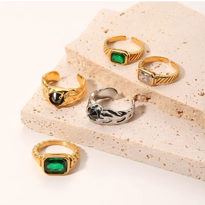 Détail de bagues en or 18k et argent serties d'émeraudes et de pierres de zircon
