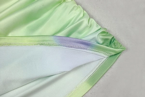 Detailed view of high-stretch fabric with green-purple gradient and pleated stitching