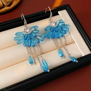 Gros plan de boucles d'oreilles bohèmes en cristal bleu sur doublure en velours