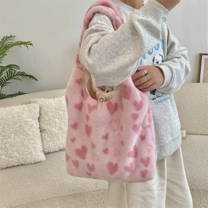 Detail of soft plush shoulder bag with heart patterns on faux fur material