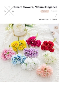 Flat lay of colorful artificial silk flower bouquets on white lace crochet tablecloth