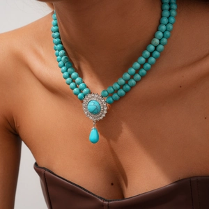 Detail of bohemian layered necklace featuring turquoise beads and water drop pendant