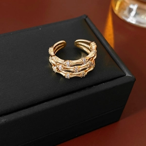 Macro shot of three-layered bamboo-shaped gold ring with white zircons on leather box