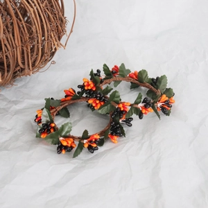 Orange and black pip berry wreath with green leaves for Thanksgiving and Halloween decor
