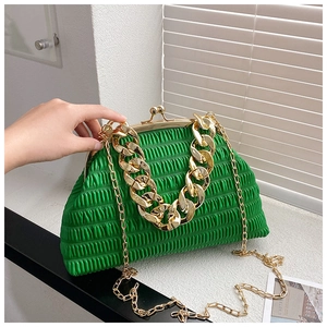 Detail of green pleated shell bag with gold chunky chain handle and snap closure