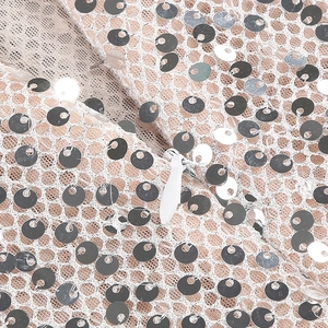Detail of invisible zipper on back of silver sequin evening dress with mesh lining