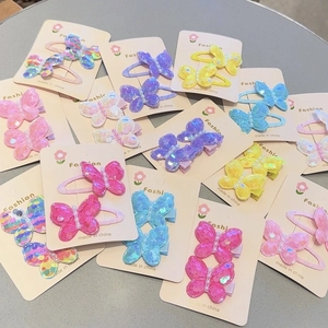 Detailed view of sequin butterfly hair clips with pearls on display cards