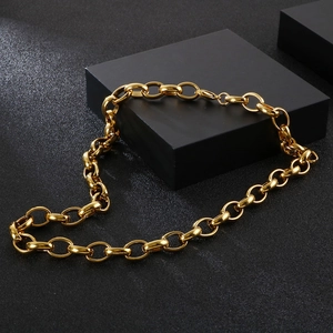 Close-up of golden chunky chain link necklace with polished finish on black background