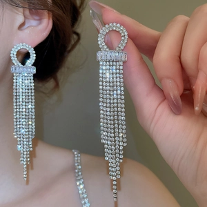 Close-up of silver tassel earrings with sparkling cubic zirconia on a model