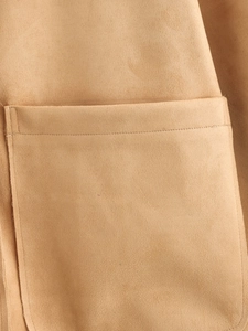 Gros plan détaillé du tissu en daim marron clair avec des coutures soignées sur la poche