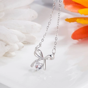 Elegant silver necklace with bow design and sparkling heart-shaped zircon pendant