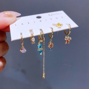 Detail of 6-piece gold earrings set featuring zircon bear and astronaut charms