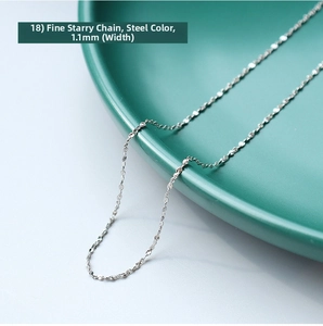 Detailed macro view of a 1.1mm fine steel sparkling chain necklace on a ceramic tray