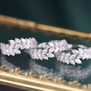 Macro shot of silver wheat leaf ring set with marquise cut gems on vintage gold mirror