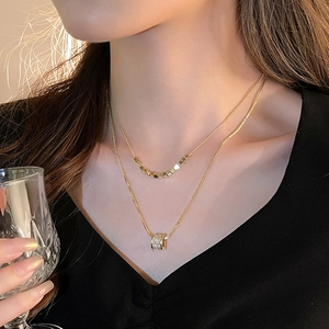 Detail of 18k gold plated double-layer necklace with zircon pendant on a model
