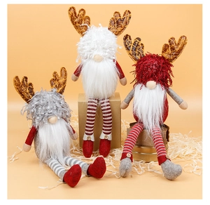 Three long-legged Christmas gnomes with reindeer antlers sitting in a festive gift box