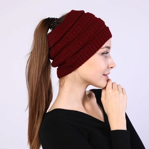 Detail view of burgundy knitted ponytail headband showing the top opening and texture
